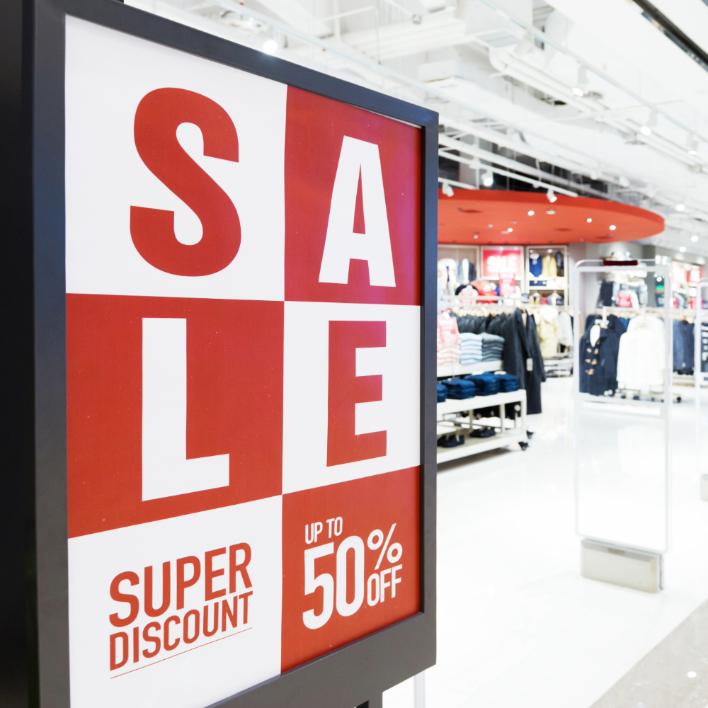A sign in the mall for a 50% off sale, red and white boxes design